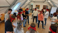 Das Bild zeigt eine Gruppe Anwärter*innen des Studienseminars für BBS Neuwied in einem Raum beim Ausprobieren des Spiels "Blind ein Quadratlegen" zur Teambildung