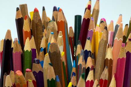 Das Bild zeigt eine Nahaufnahme von Bleistiften mit unterschiedlicher Farben, die teilweise angespitzt und teilweise stumpf sind.