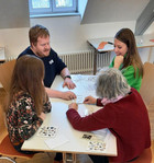 4 Teilnehmer:innen an einem Tisch beim Legen von Karten in der richtigen Reihenfolge